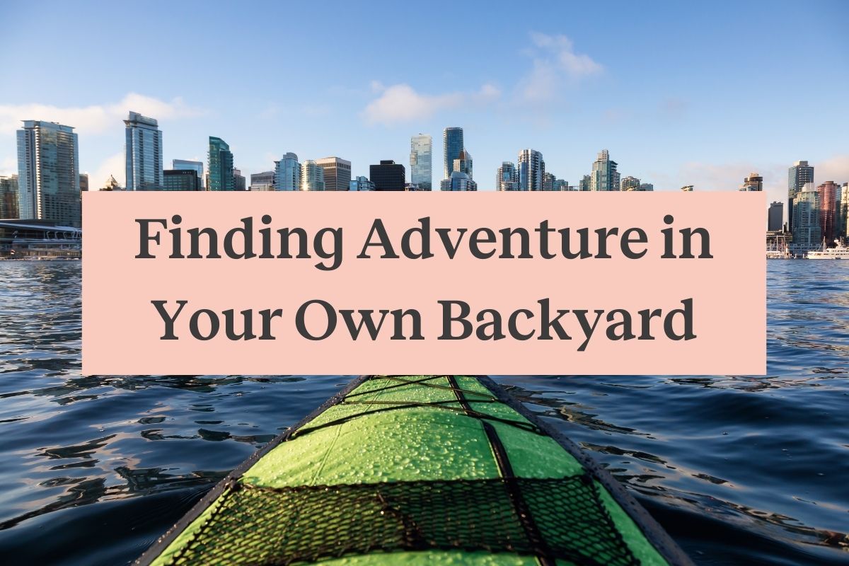 The front of a green kayak in the water and a city skyline in front of it, with a pink rectangle and the words "Finding adventure in your own backyard"